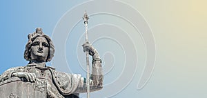 Top statue of a woman warrior with shield and spire at Austria Fountain in Freyung Square, downtown, Vienna, Austria