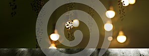 Top of table with hanging classic black metal light bulb in night time interior on dark green banner background