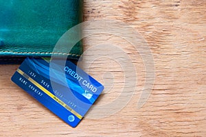 Top table view of mock up blue credit card insert between wallet with copy space