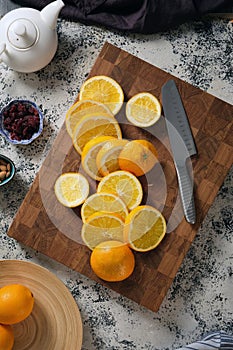 On top there are many sliced oranges on a beautiful wooden board