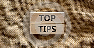 Top tips symbol. Concept words Top tips on wooden blocks on a beautiful canvas background. Business and Top tips concept, copy