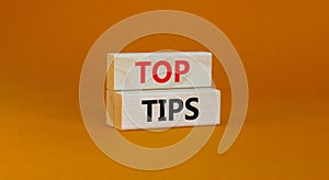 Top tips symbol. Concept words Top tips on wooden blocks on a beautiful orange background. Business and Top tips concept, copy