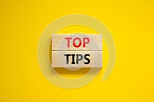 Top tips symbol. Concept words Top tips on wooden blocks on a beautiful yellow background. Business and Top tips concept, copy