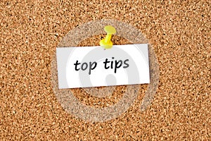 Top tips. Text written on a piece of paper, cork board background