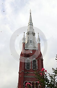 The top of tower church with the tree and cloud on blue sky background at cathedral of the holy trinity.