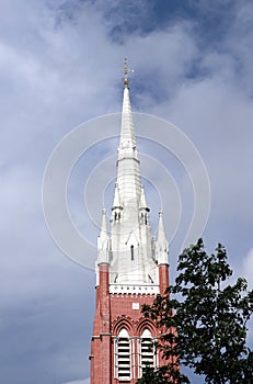 The top of tower church with the tree and cloud on blue sky background at cathedral of the holy trinity.