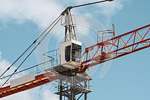 Top of a tower crane with a boom and a crane operator`s cab