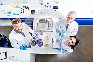 Top up of lab team of three researchers working with reactants a photo