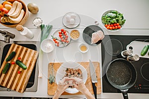 Top vie hoto of females` hands pickling the meat