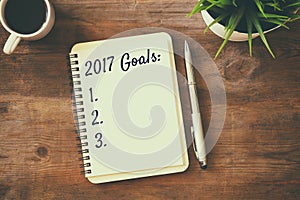 Top view 2017 goals list with notebook, cup of coffee