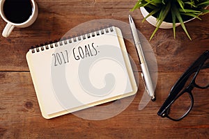 Top view 2017 goals list with notebook, cup of coffee