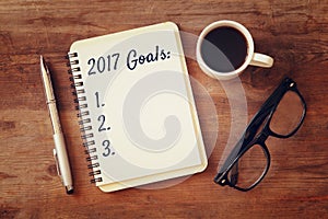 Top view 2017 goals list with notebook, cup of coffee