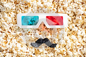 top view of 3d glasses and artificial mustache on scattered popcorn, cinema concept.