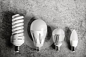 Top view of 4 different e27 household light bulbs on a gray background