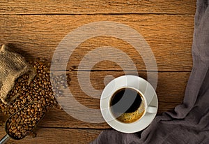 Top view above of Black hot coffee for morning with milk foam for morning menu in white ceramic cup with coffee beans roasted