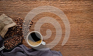 Top view above of Black hot coffee for morning with milk foam for morning menu in white ceramic cup with coffee beans roasted