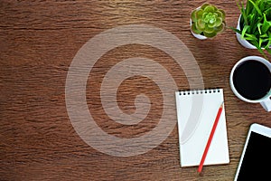 Top view from above of Blank open notebook and coffee on wood table background. Workplace for the creative work of designer at hom