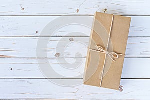 Top view above brown gift box on wooden background with space.