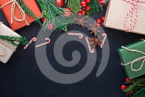 Top view above of Christmas holiday background. Composition with fir pine branches, Gift kraft box decorations on black background