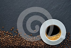 Top view, above from of Hot fresh black coffee with milk foam for morning menu in white ceramic cup with coffee beans roasted on d