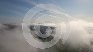 Top view from above of landscape covered with puffy morning fog. Cold humid air condensing in rain clouds