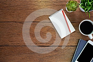 Top view above of Wood office desk table with Blank open notebook, pen and phone with equipment other office supplies. Business an