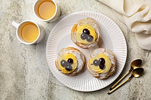 Top view of above, Zeppole di San Giuseppe, zeppola - baked puffs made from choux pastry, filled and decorated with custard cream