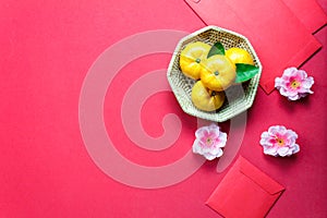 Top view accessories Chinese new year festival decorations.orange,leaf,wood basket,red packet,plum blossom on red background.