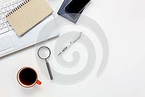 Top view accessories office desk concept.mobile phone,notepaper,pen,laptop,Magnifier on white office desk.