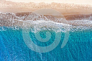 Top view aerial drone photo of Perissa beach with beautiful turquoise water and sea waves. Vacation travel background. Aegean sea