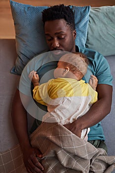 Top view African American father with baby son sleeping together at naptime