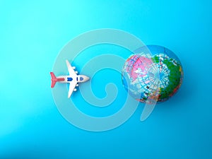 Top view airplane with earth globe on a blue sky background