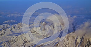top view through airplane of mountain ranges with snow of switzerland, winter holidays