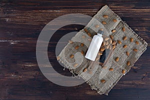 Top view of almond milk with sesame in a plastic bottle with almonds nut and sesame seeds on rustic fabric wooden tray and table.