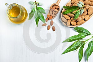 Top view Almond nuts and oil in wooden shovel, almonds with shell in bamboo bowl