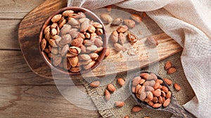 Top view of Almonds are unpeeled and some peeled on wooden table background. Healthy foods concept