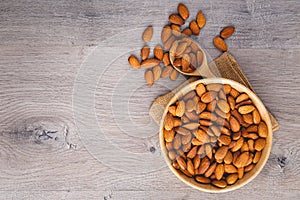 Top view of almonds on wooden table with wood spoon or scoop photo