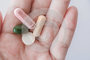 Top view of alternative organic medicine or herbal viatmin supplement capsule tablet on woman hand with copyspace background.