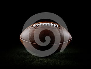 Top view of American Football Ball on green grass and black background. AI Generated Image