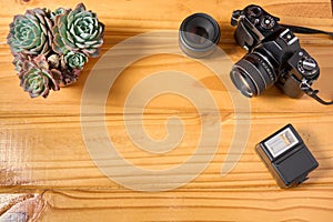 Top view of analog camera, flash and lens on wooden table, professional photography equipment. Photography background with copy sp