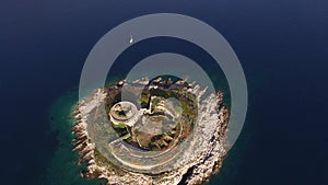 Top view of the ancient fortress Mamula, a yacht near it and the coast of the bay
