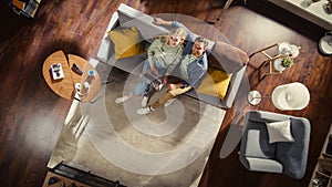 Top View Apartment: Happy Couple In Love Using Laptop in Stylish Living Room, Hug and Look Up at