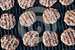Top view of appetizing beef burgers cooking on hot flame grill