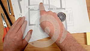 Top view, an architect`s hand with a compass looks for the orientation of the north pole, ideal footage for topics such