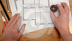 Top view, an architect`s hand with a compass looks for the orientation of the north pole, ideal footage for topics such