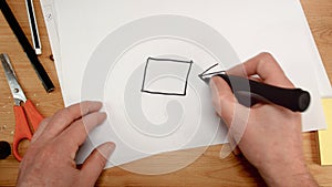 Top view, an architect`s hand draws the square base for a house, ideal footage for topics such as building renovation