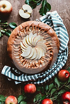 top view of arranged apple pie and fresh apples with green leaves