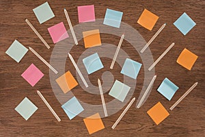 top view of arranged colorful post it notes and pencils on wooden