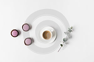 Arranged cup of coffee, desserts and plant on white tabletop photo