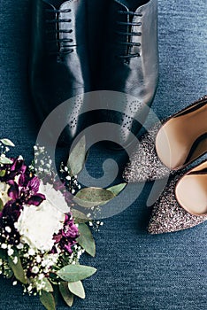 top view of arranged wedding bouquet, bridal and grooms shoes